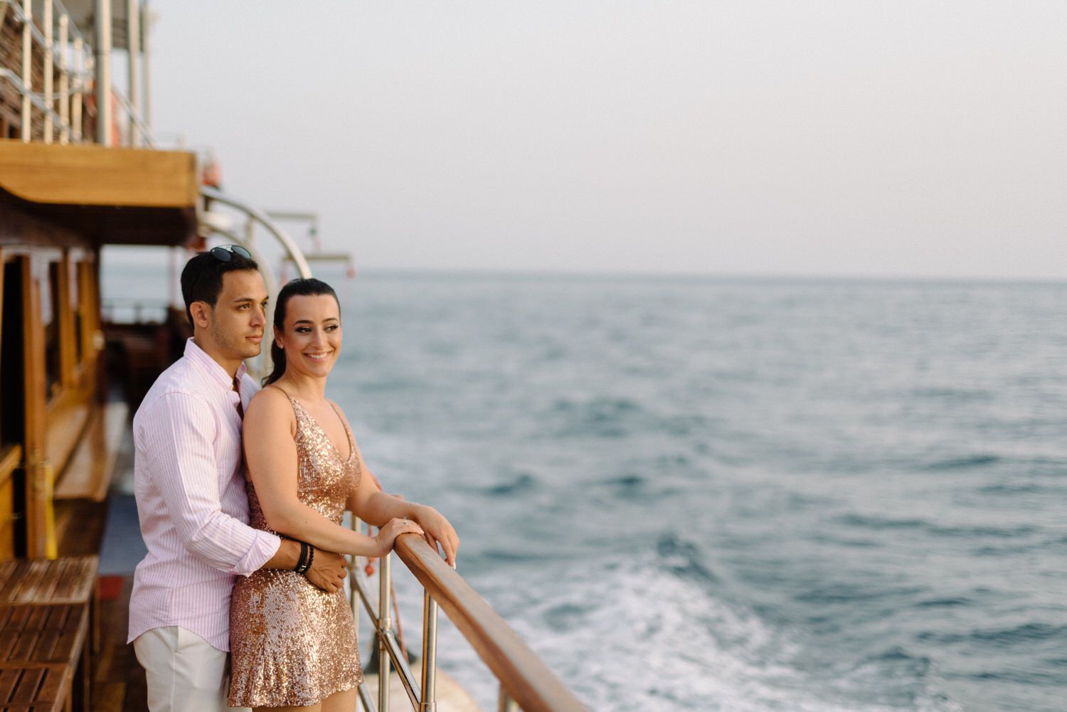 Couple standing at ship's railing overlooking the Mediterranean Sea.