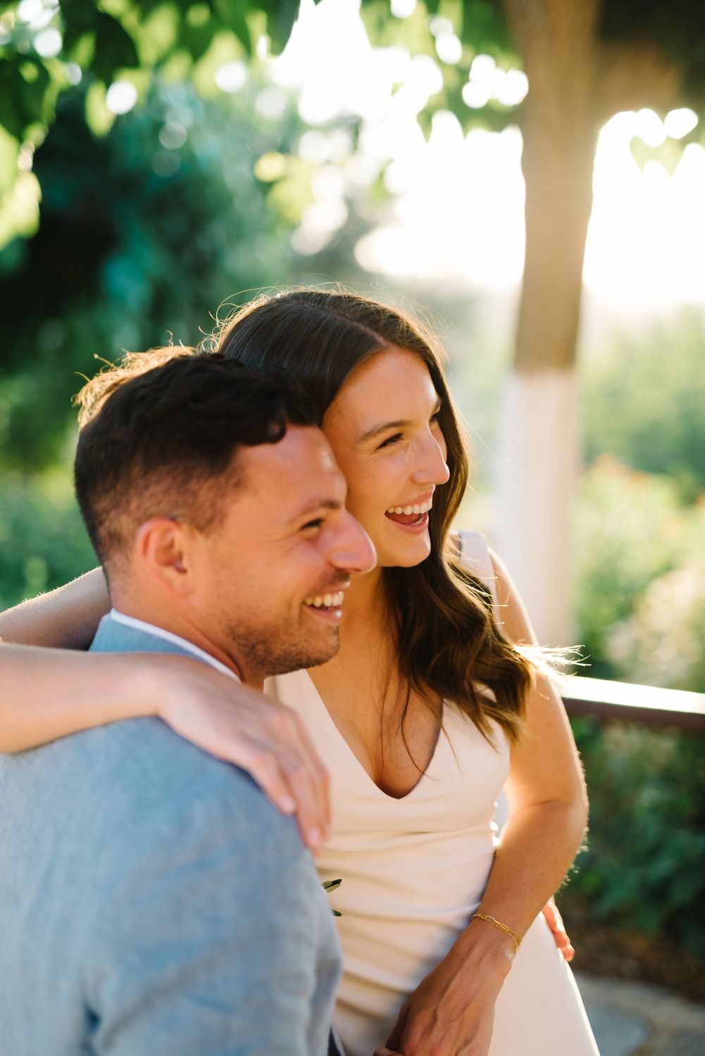 Happy couple enjoying a candid moment together in natural outdoor lighting.