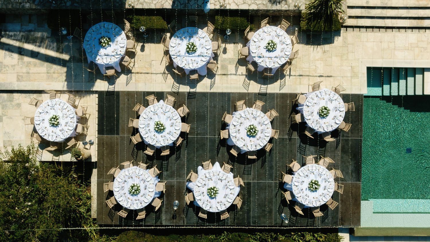 Aerial view of elegant round wedding reception tables with white linens and floral centerpieces.