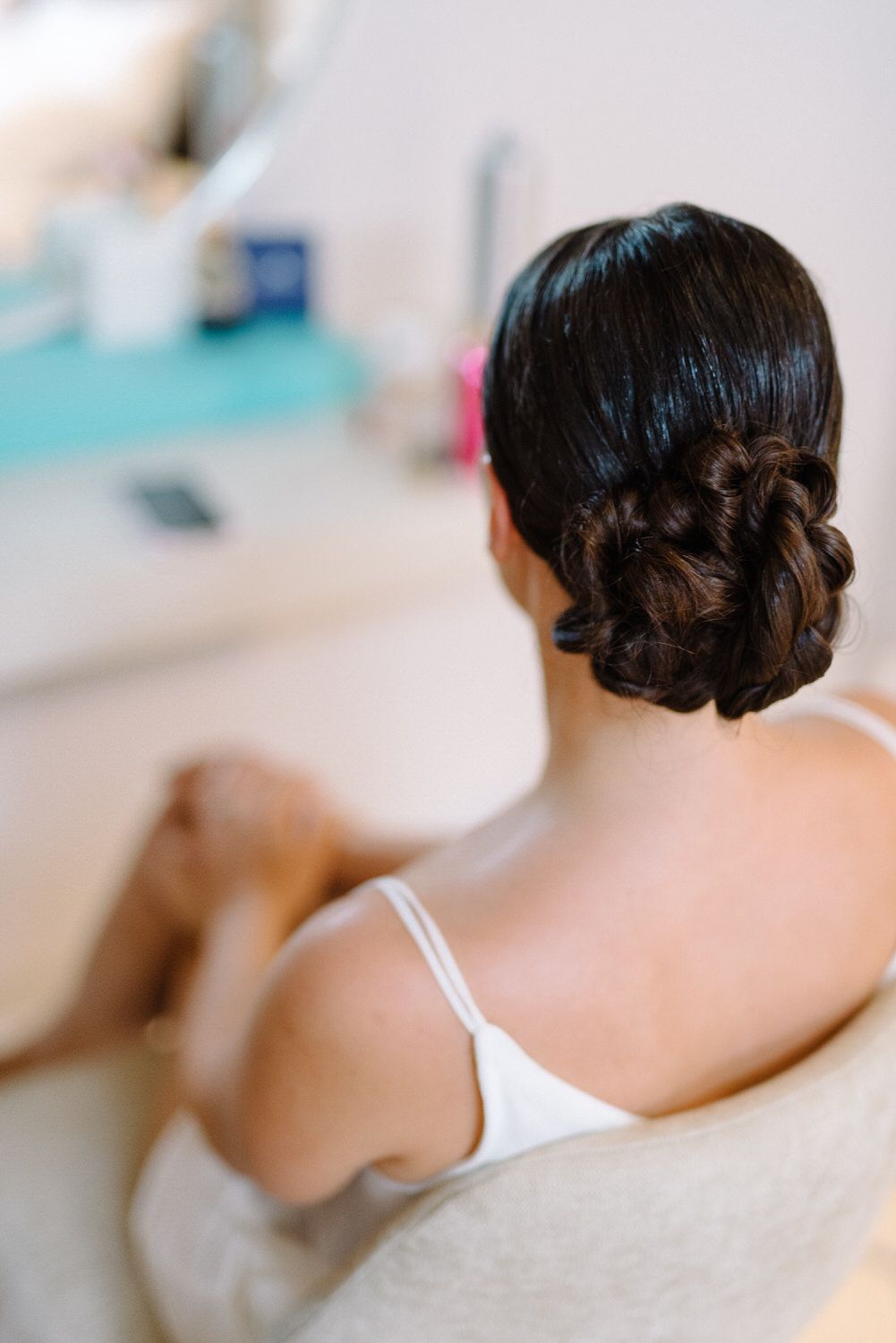 Elegant bridal updo hairstyle with dark hair styled in a classic low bun.