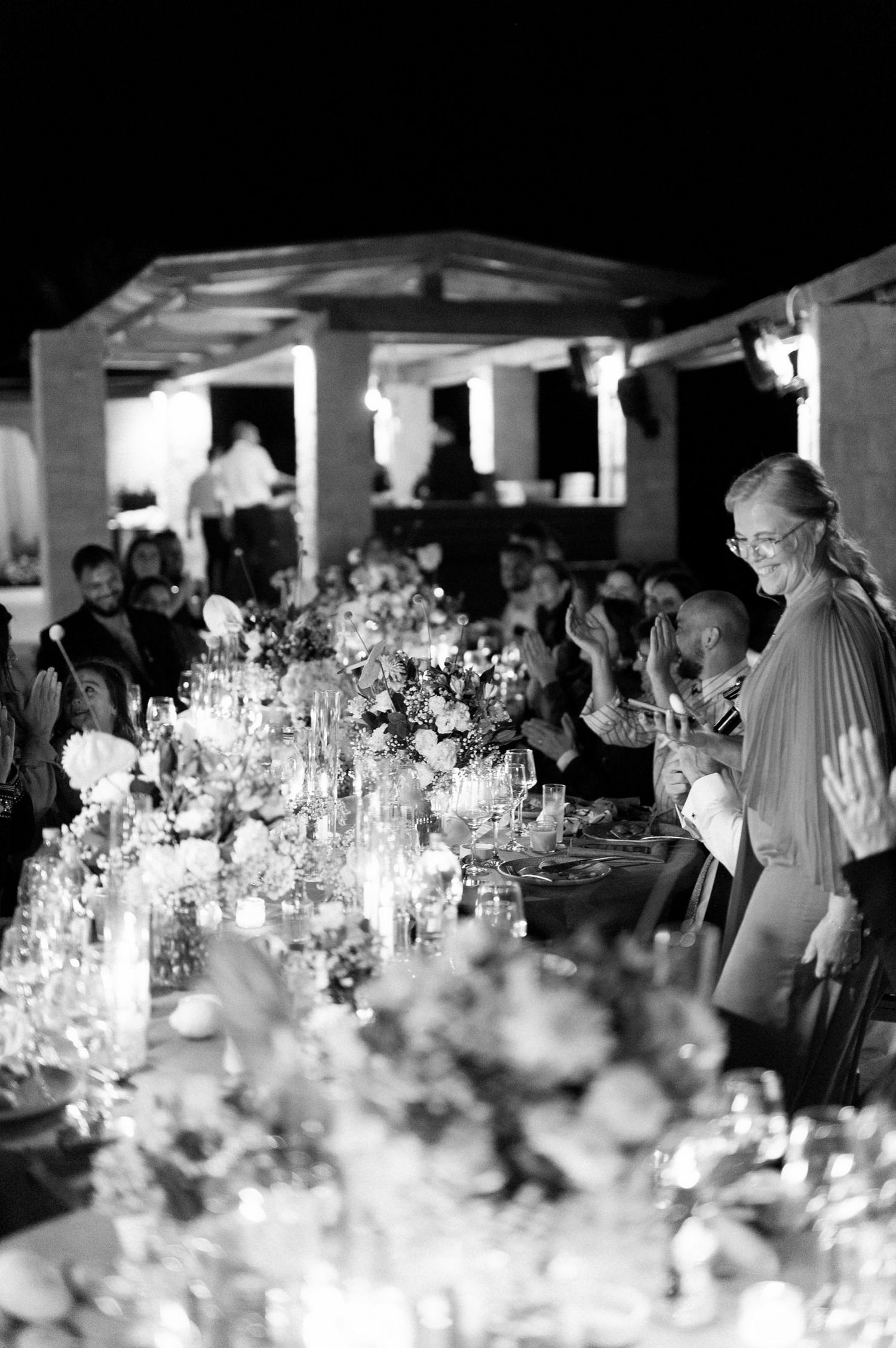 An elegant candlelit dinner table adorned with floral arrangements at a formal event.