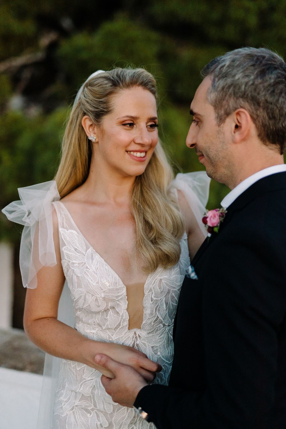 Intimate wedding moment captured against backdrop of scenic coastal town.