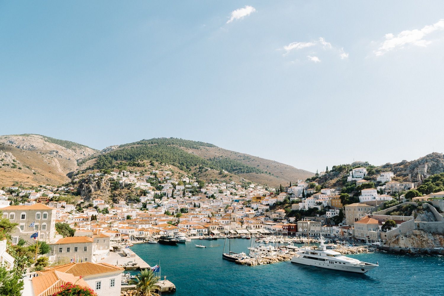Scenic coastal village nestled in hills surrounding crystal blue harbor.