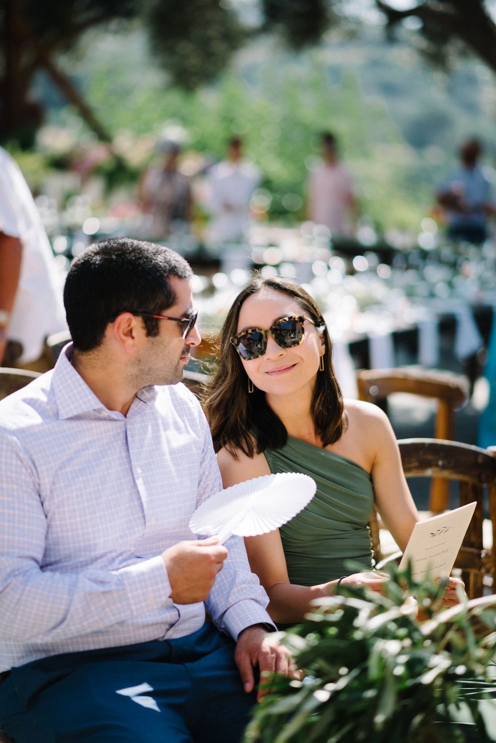 Couple enjoying refreshments at an outdoor wedding reception with mountain views.