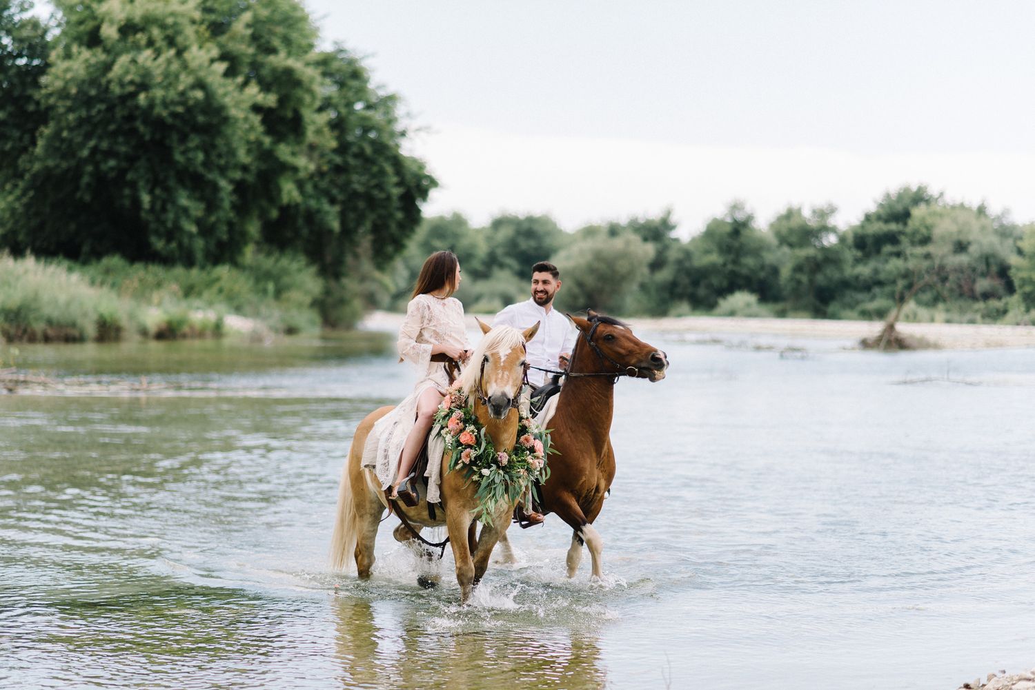 the couple is riding horses on the river Acheron in Greece