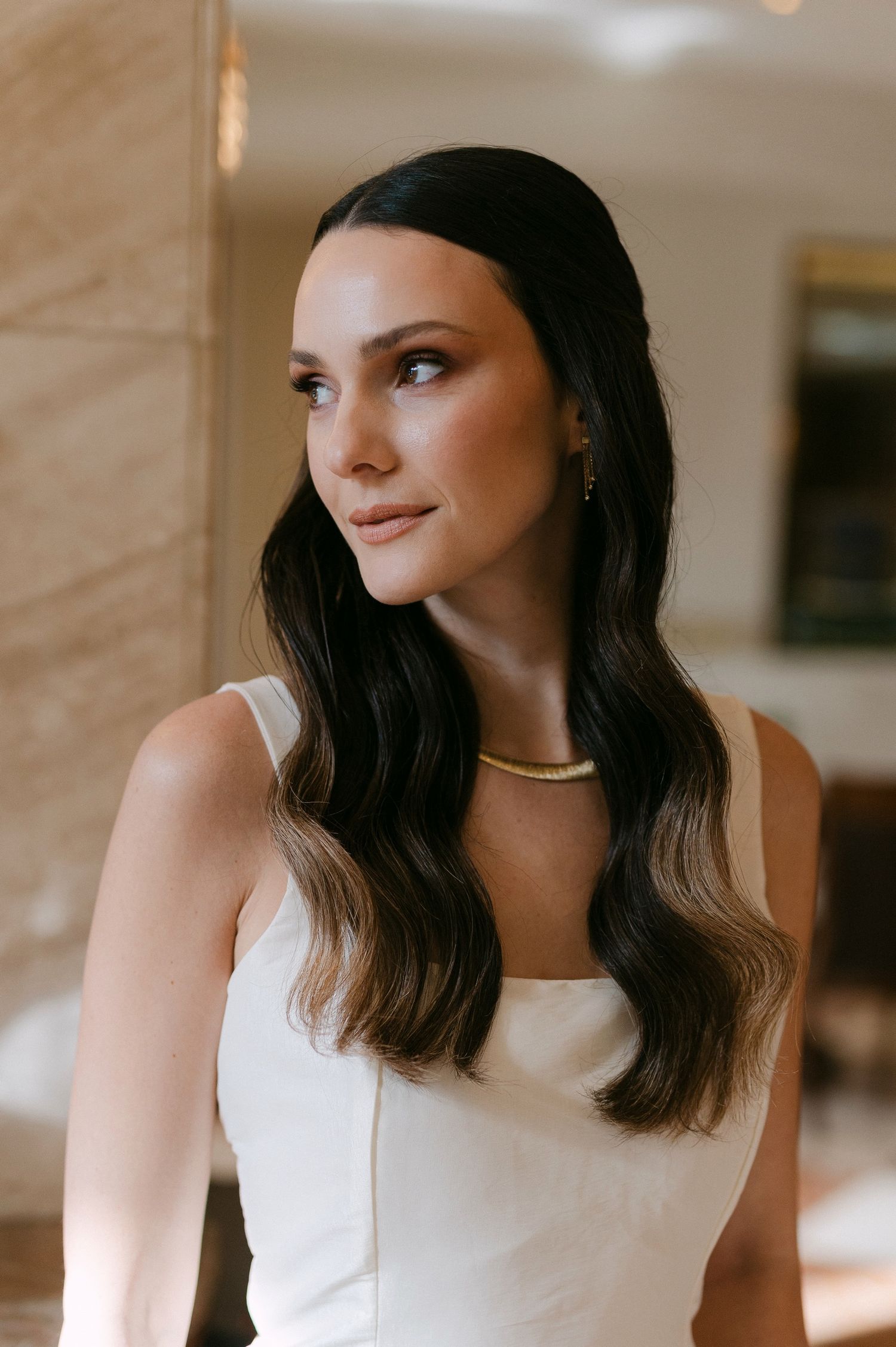 A series of candid portrait shots showing a person in a white sleeveless top against a light-colored interior background.
