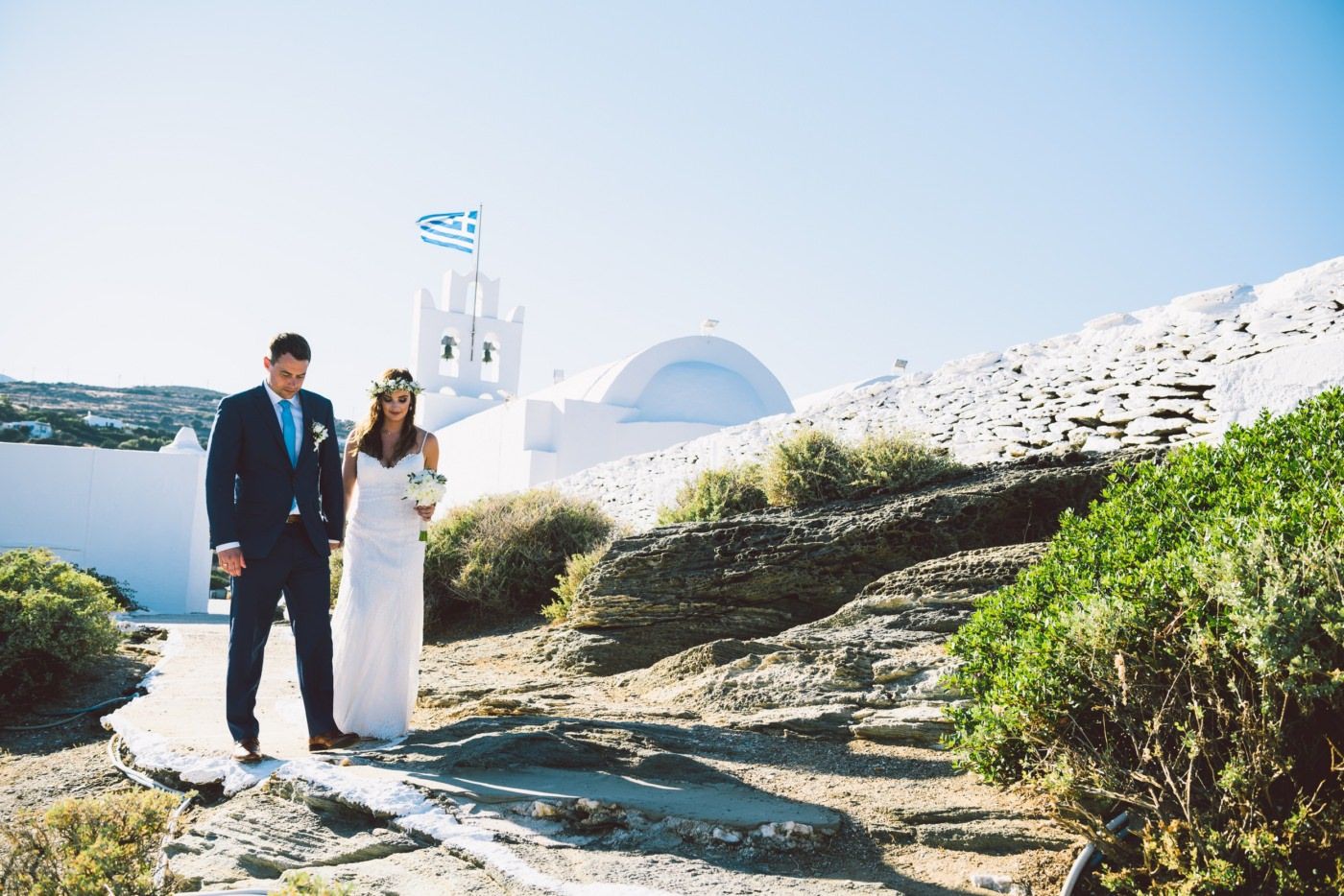 bride and groom walking near chrysopigi church at sifnos greece