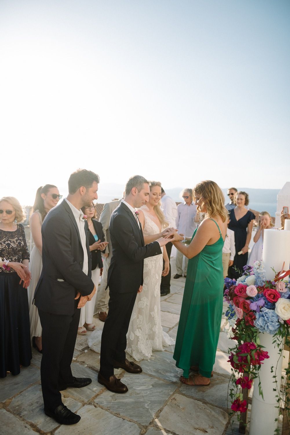 Wedding guests mingling during a celebration at a scenic outdoor venue with ocean views.