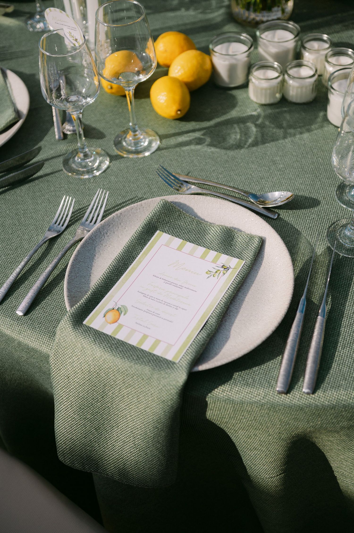 Elegant table settings with white plates, silverware, and menus on a dark gray tablecloth at a formal dining event.