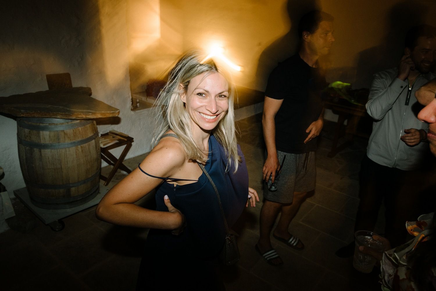 Party guest dancing enthusiastically at dimly lit nighttime celebration.