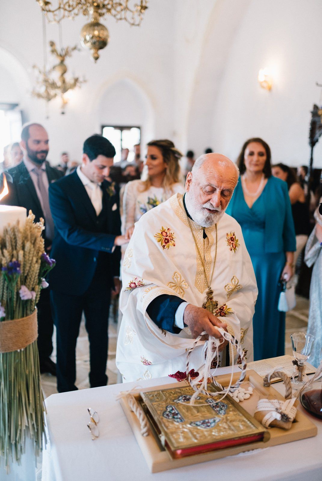 Orthodox priest performing religious ceremony rituals at altar with decorative elements.