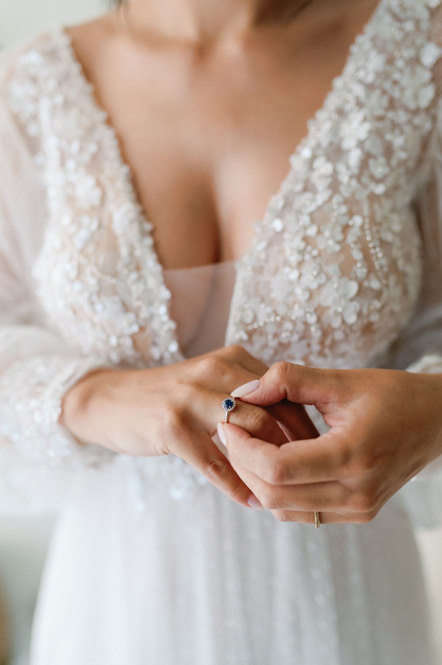 Close-up details of a beaded white wedding dress bodice with delicate embellishments and lace details.