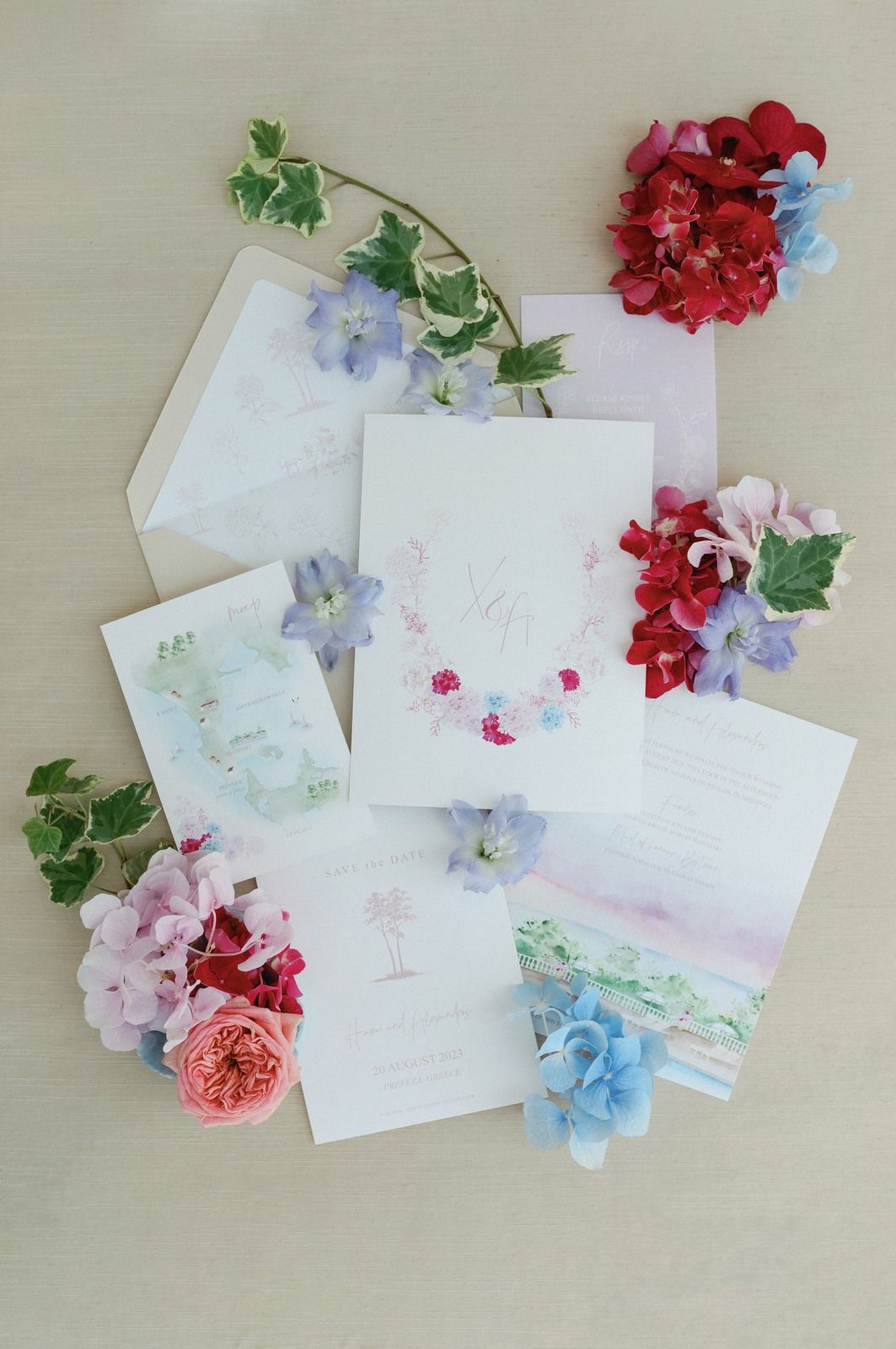 White stationery cards decorated with delicate pink, red, and blue flowers arranged in a flat lay composition.