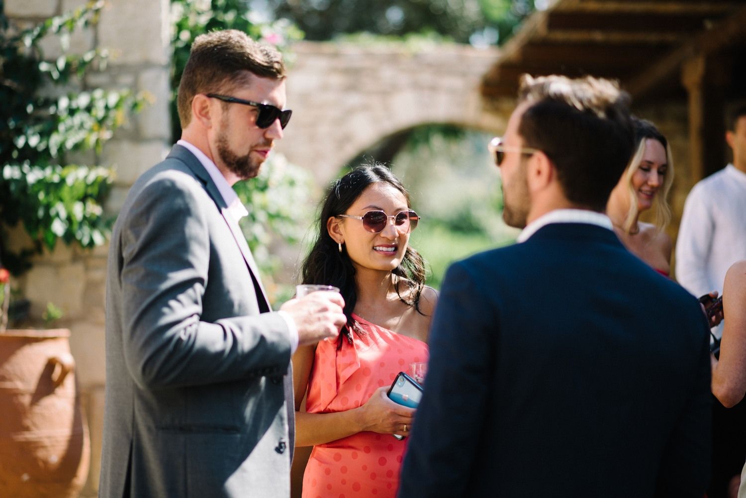 Wedding guests socializing and mingling at an outdoor garden reception.