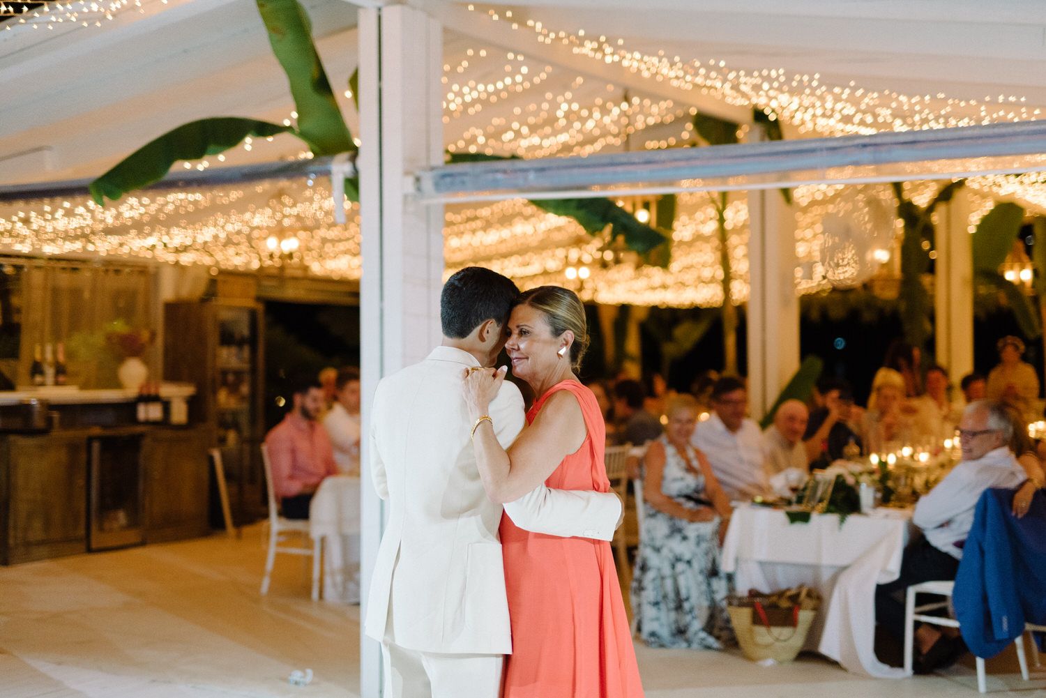 Intimate moment shared during an evening wedding reception under sparkling string lights.
