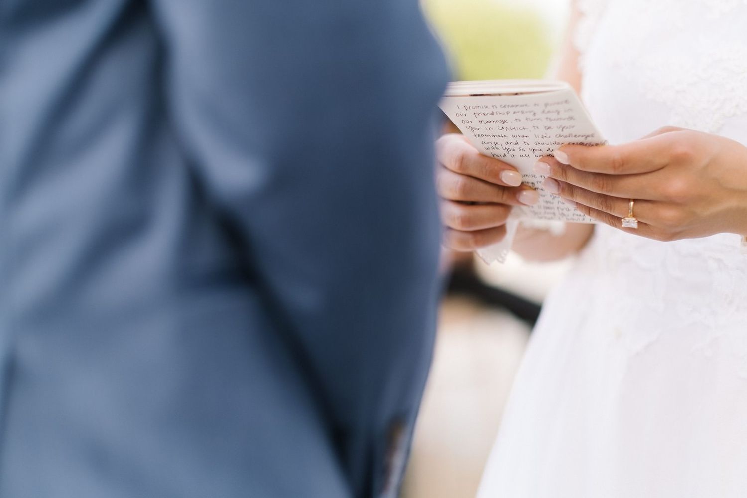 Hands holding paper during wedding ceremony reading.