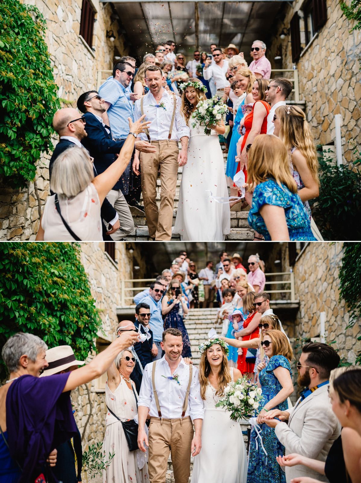 Wedding party celebrates on rustic stone stairway surrounded by greenery and guests.