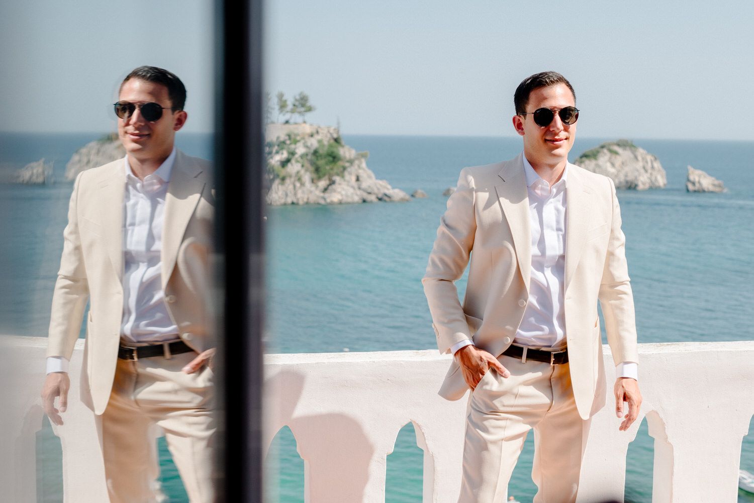 Two images of a person in beige suit and sunglasses posing on a seaside terrace.