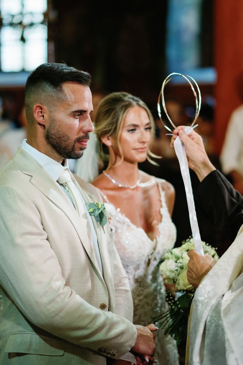 Orthodox wedding ceremony with priest holding symbolic items during traditional service.