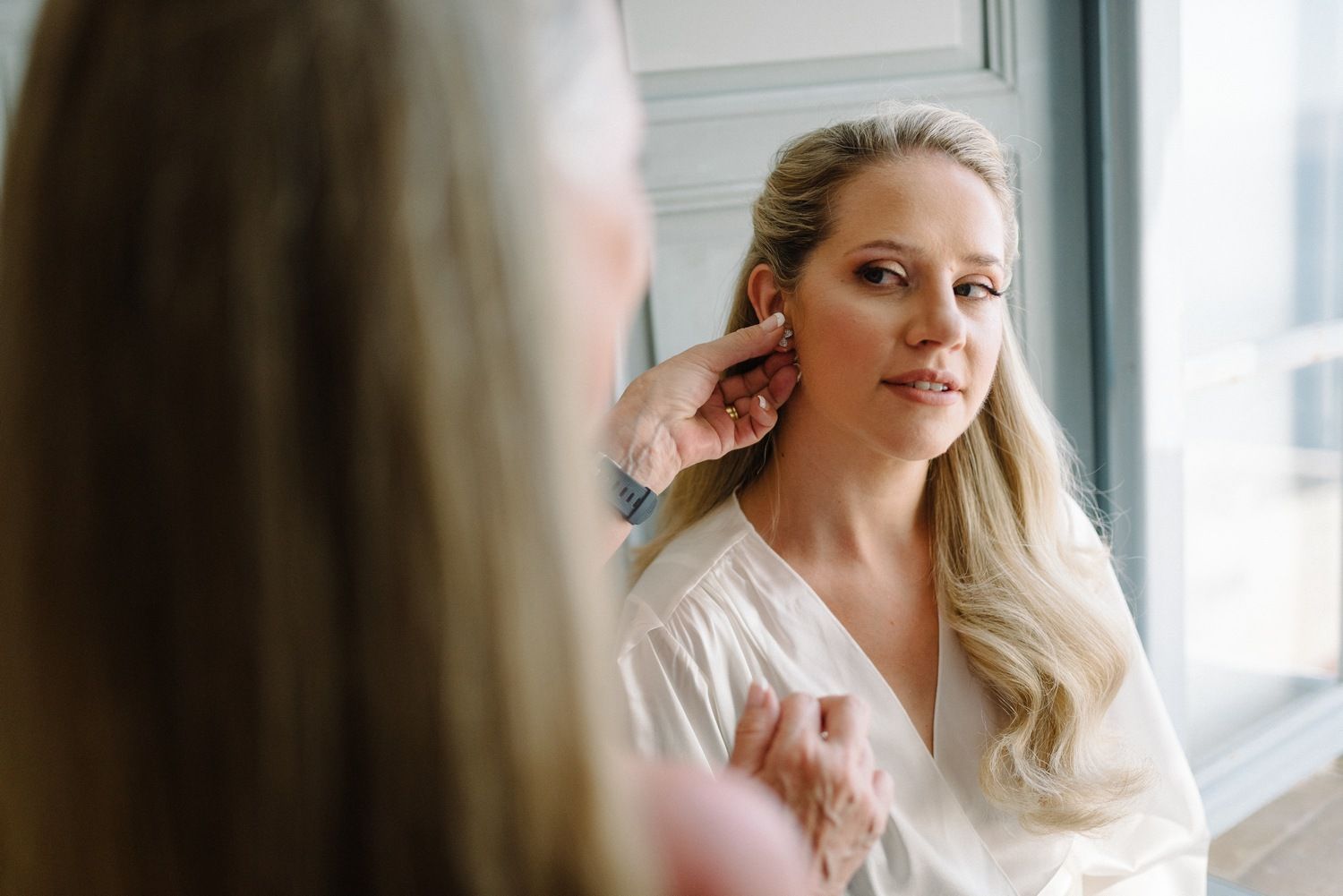 Getting ready scene with soft natural light streaming through a window.