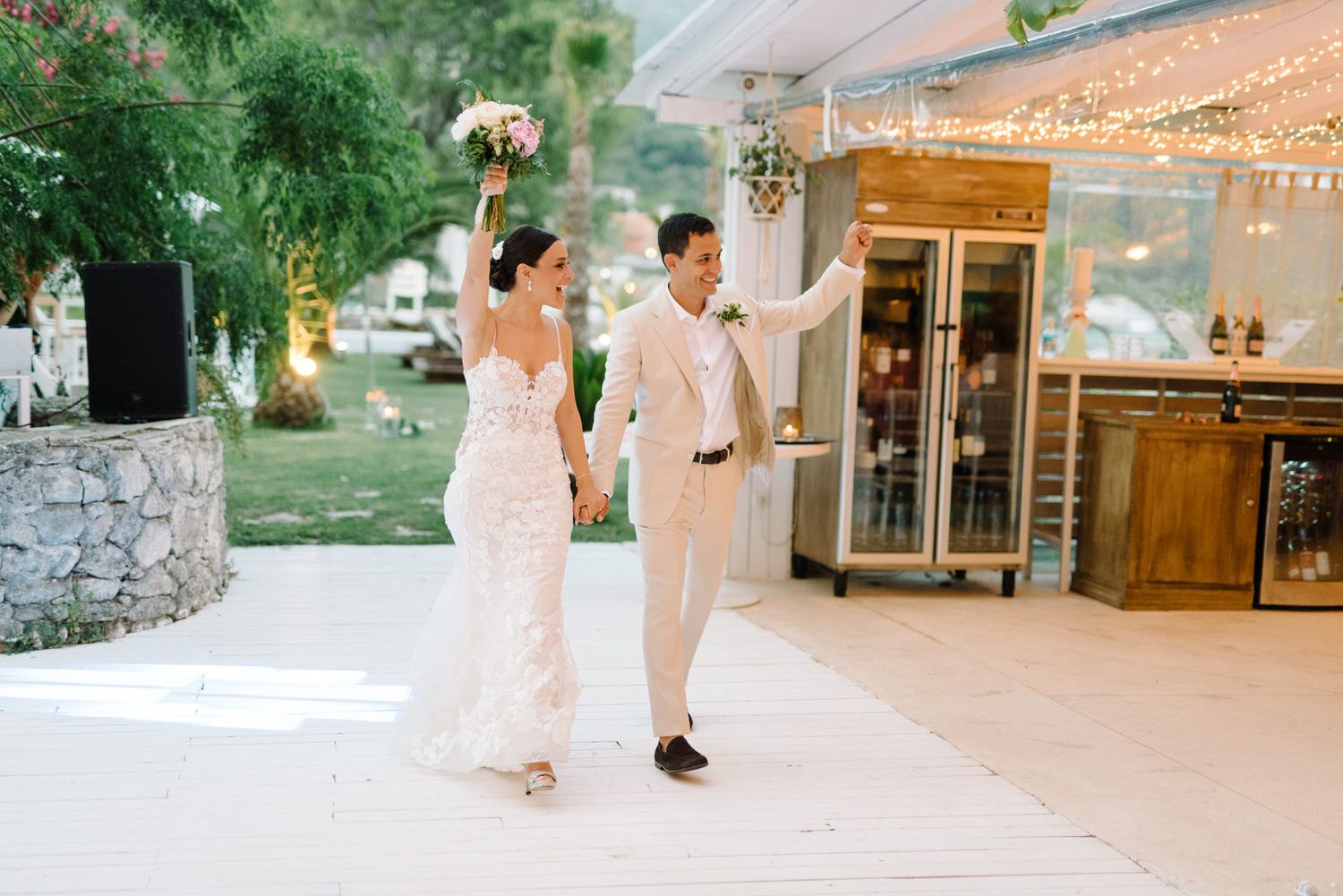 Outdoor wedding venue decorated with string lights and elegant reception setup.
