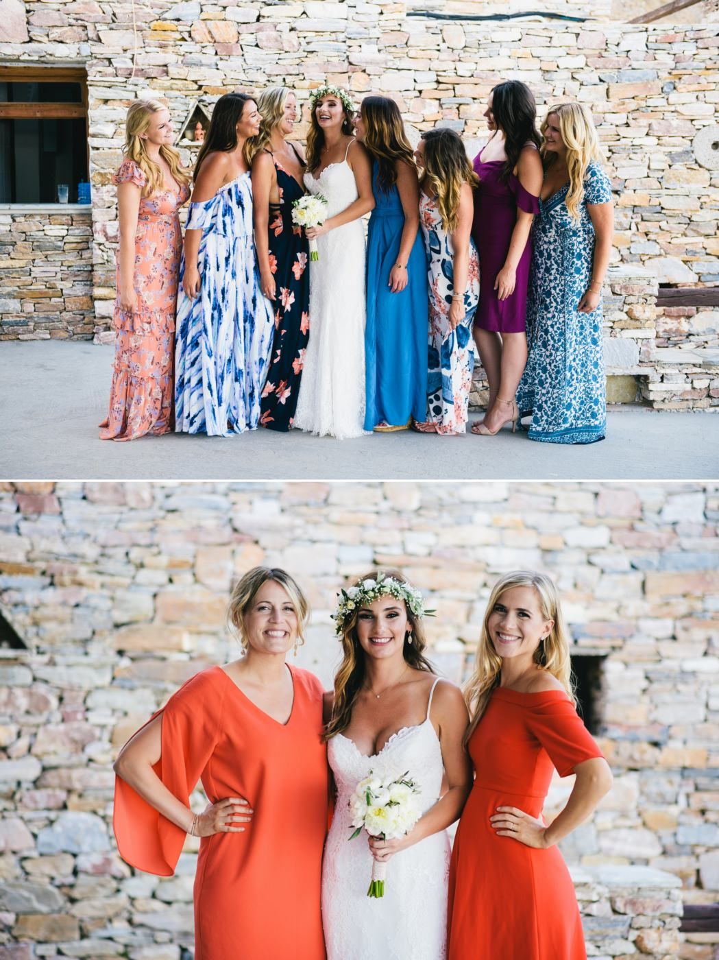 Wedding party in colorful dresses posing against rustic stone wall backdrop.
