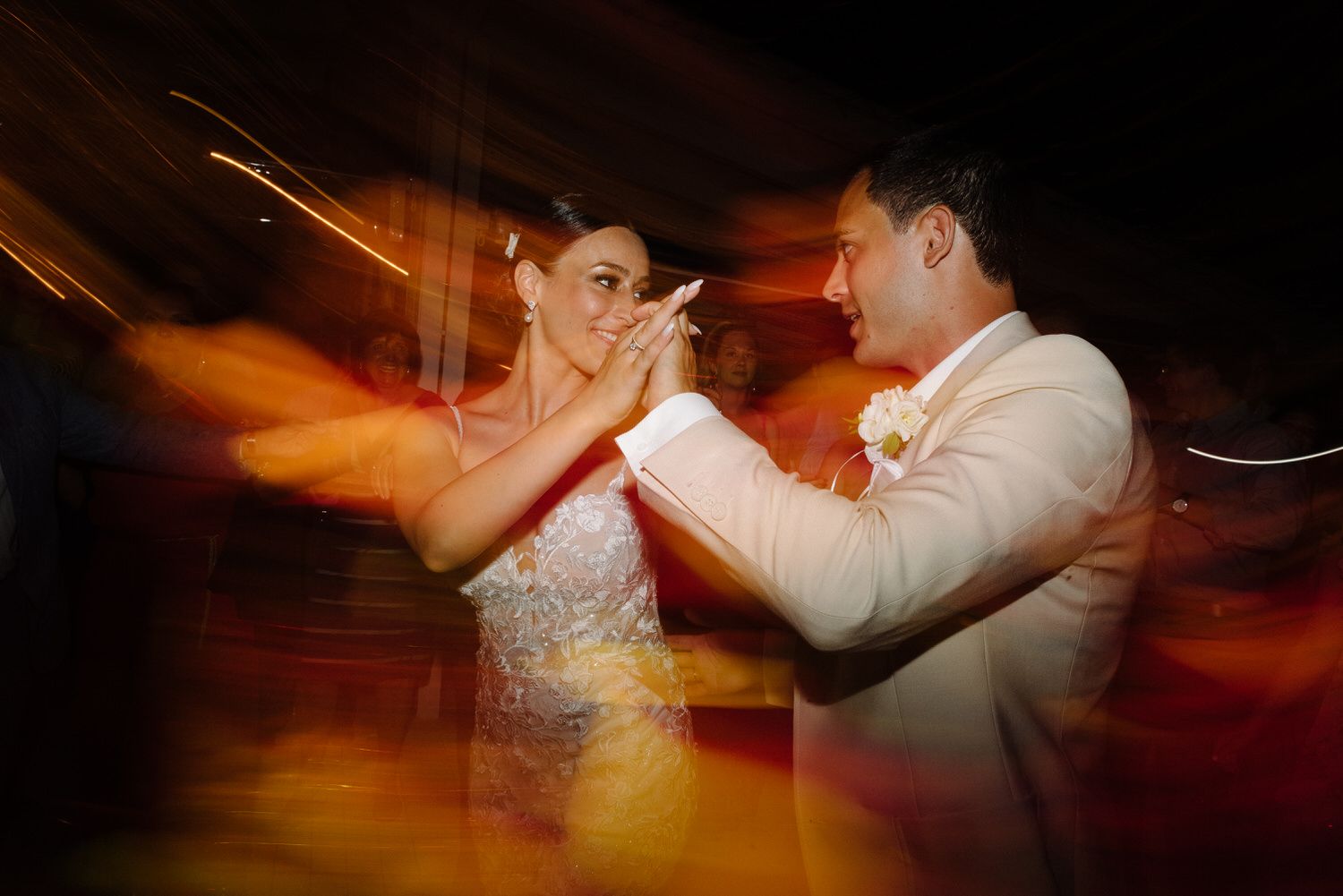 Wedding celebration captured in motion with warm amber lighting and dance floor energy.