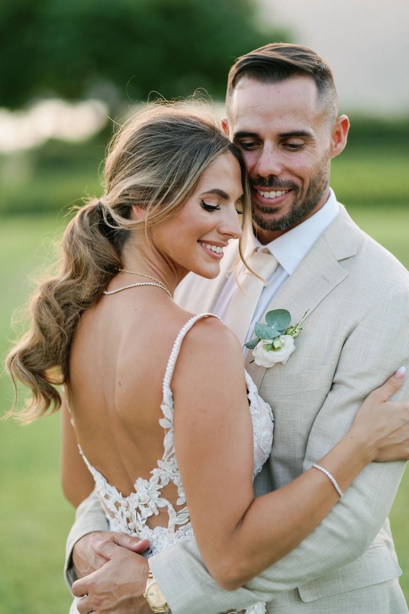 Intimate portrait of newlyweds embracing in natural outdoor setting.