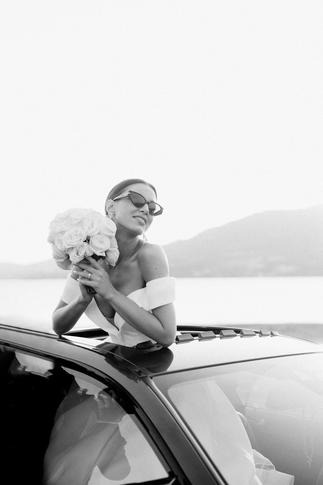 A black and white photo series shows someone in sunglasses leaning out of a car window against a bright sky.