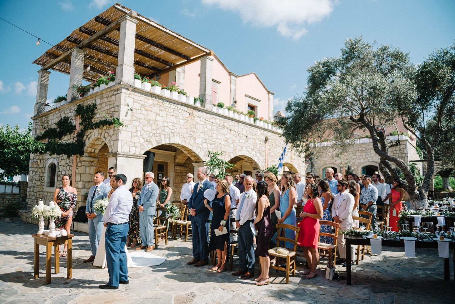 Wedding guests gathered outside a beautiful Mediterranean stone villa.