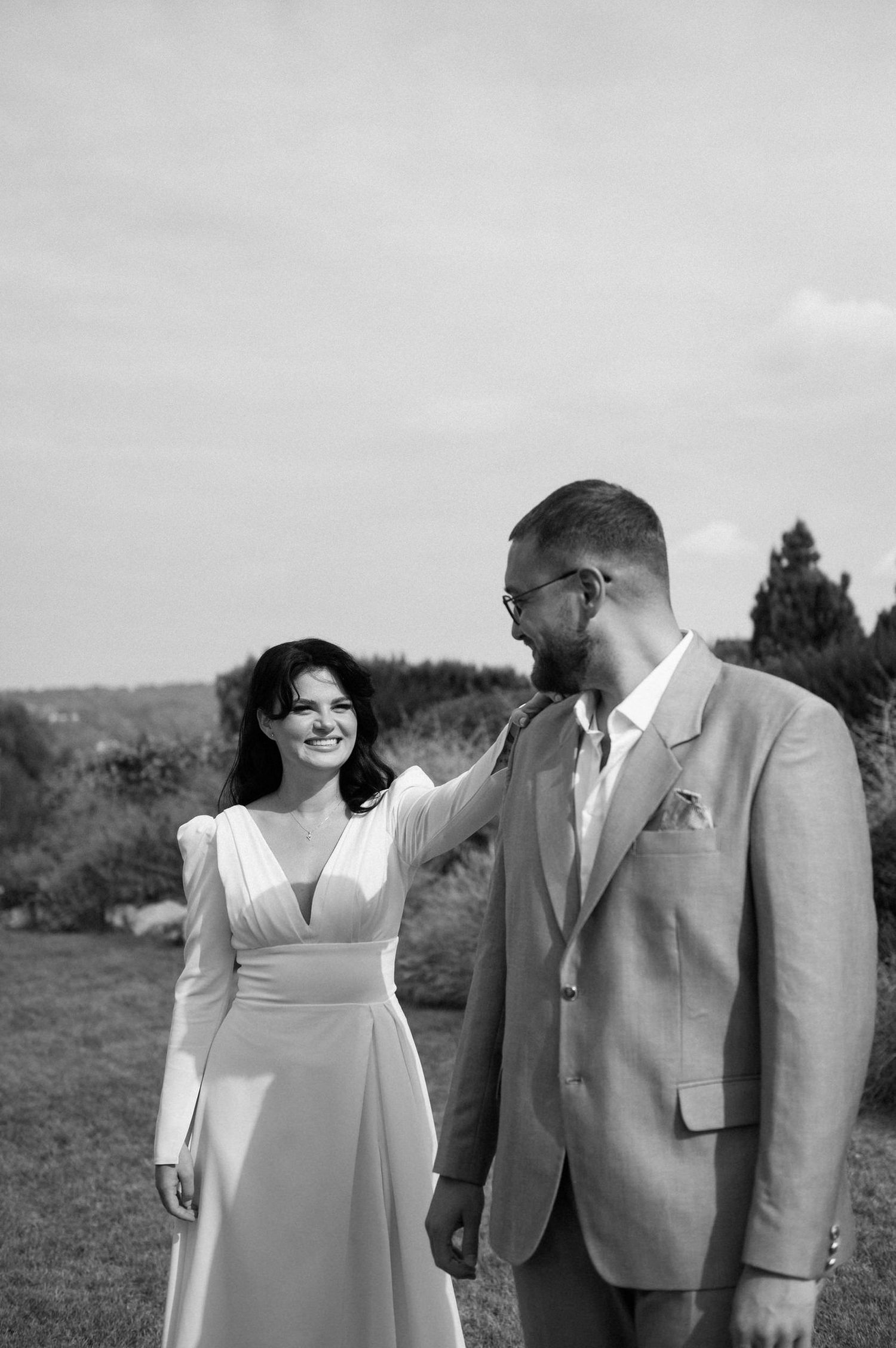 A romantic black and white wedding photo series showing a couple in formal attire sharing intimate moments outdoors.