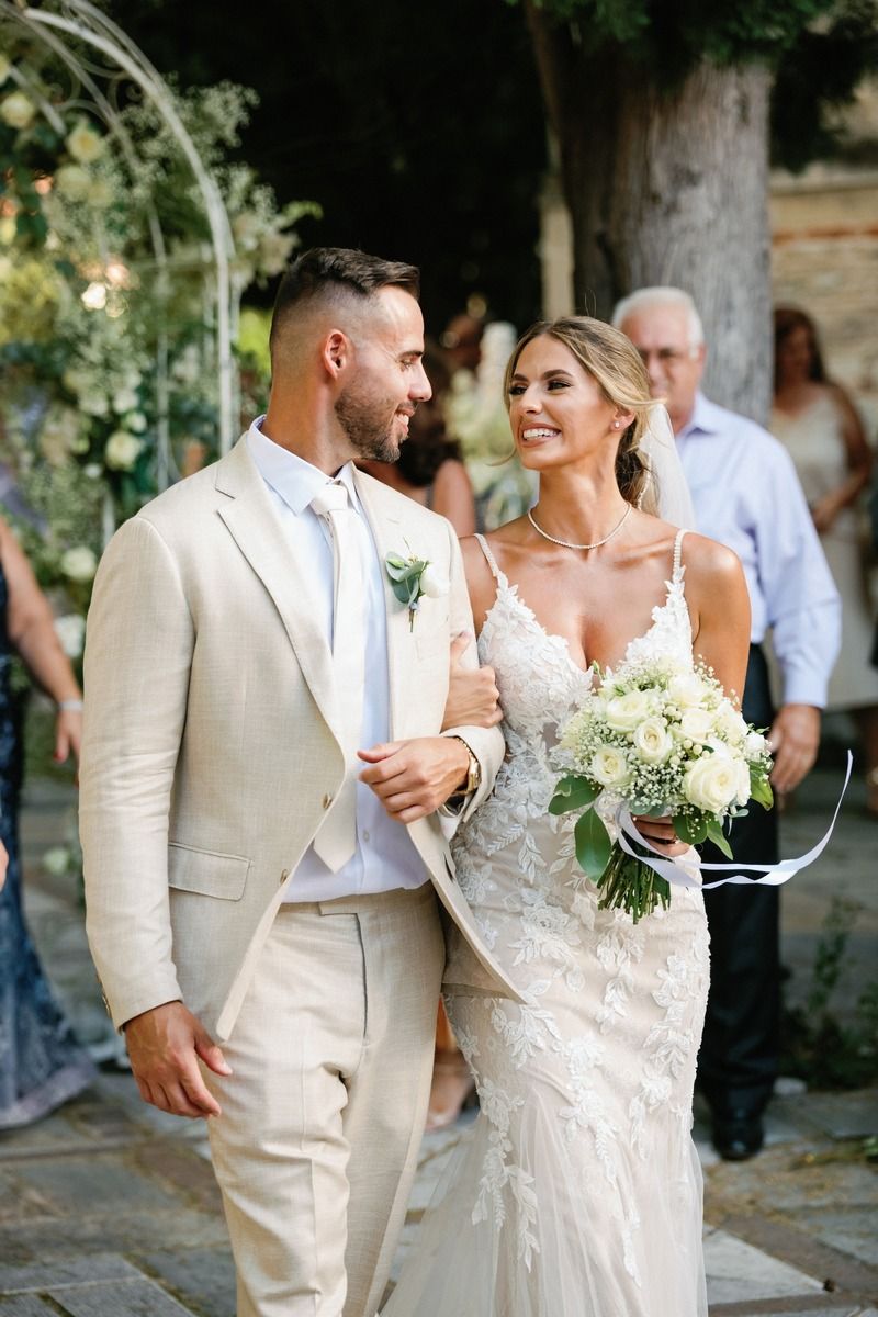 Couple in wedding attire walking together and sharing a joyful moment.