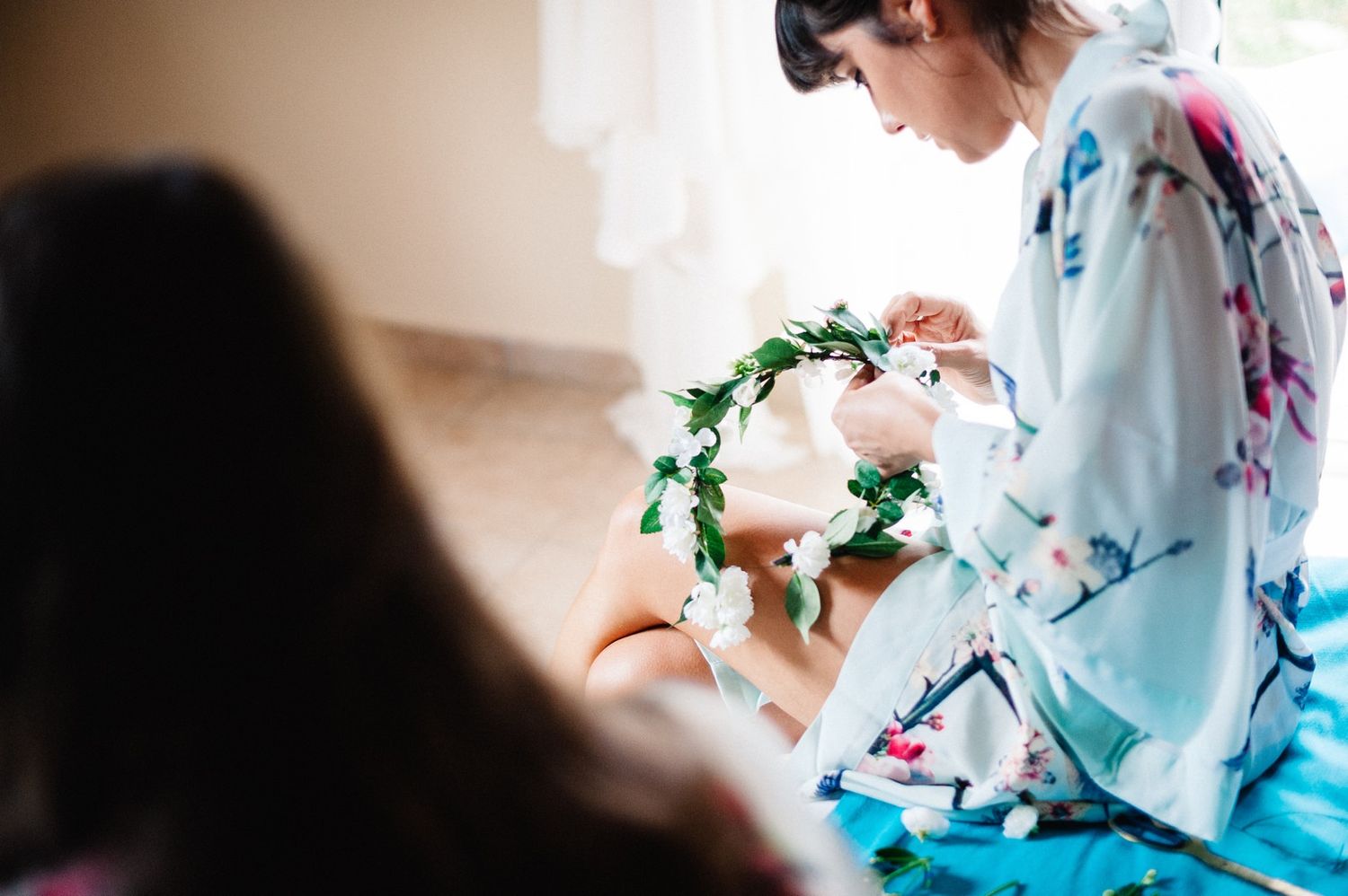Delicate floral crown being prepared with pink and white blooms.