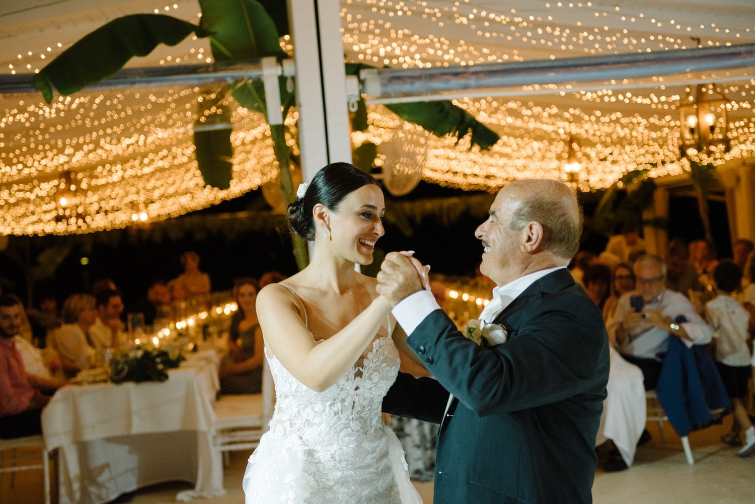 Dancing moment captured during an evening wedding reception under warm string lights.