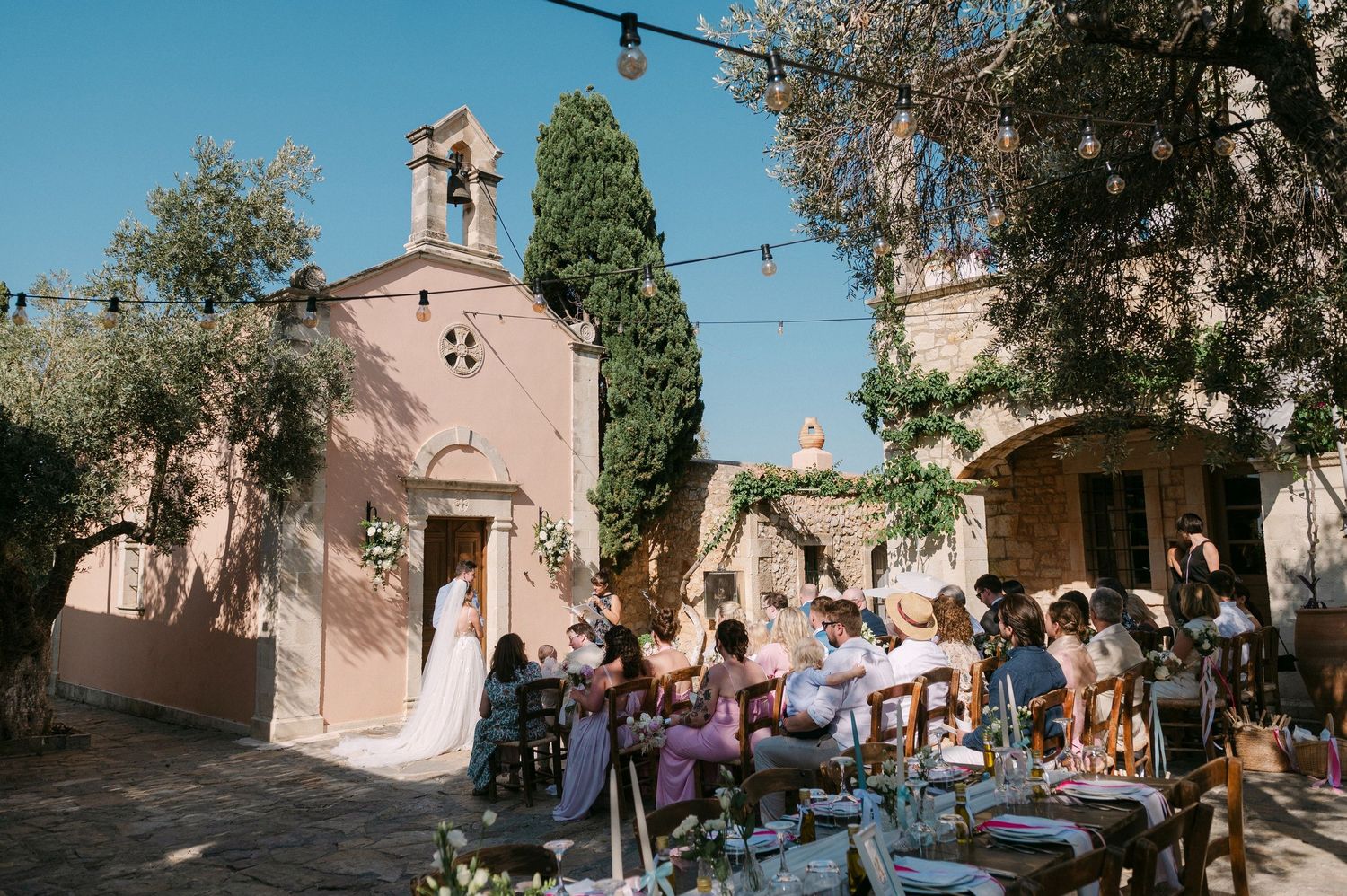 A sequence of film photographs showing a rustic Mediterranean church exterior and outdoor gathering in warm sunlight.