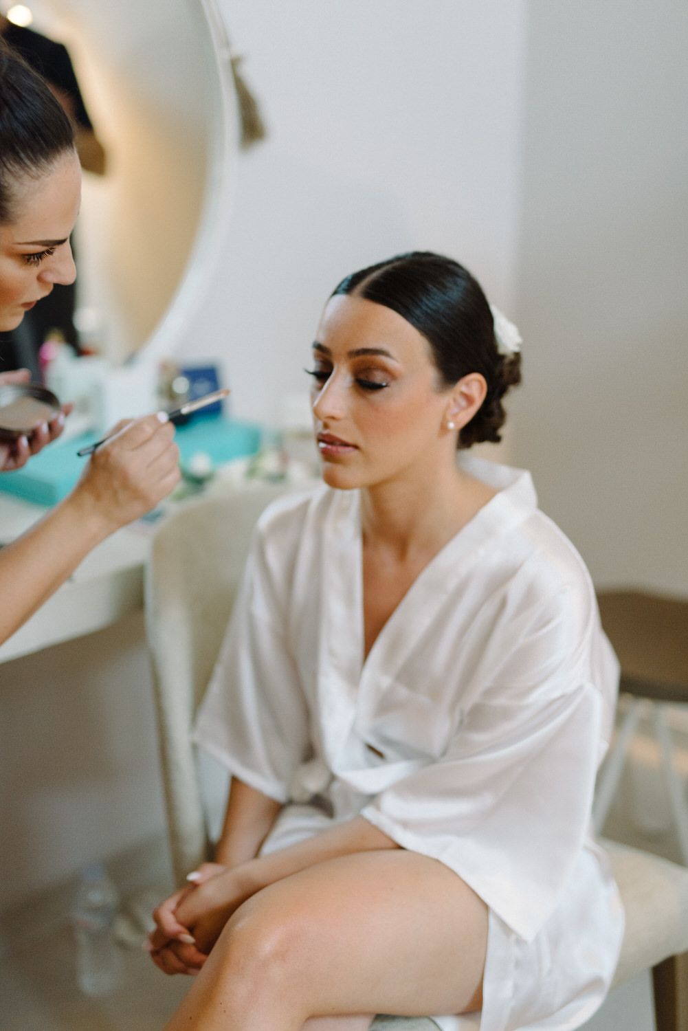 Wedding day makeup application in progress with professional artist.