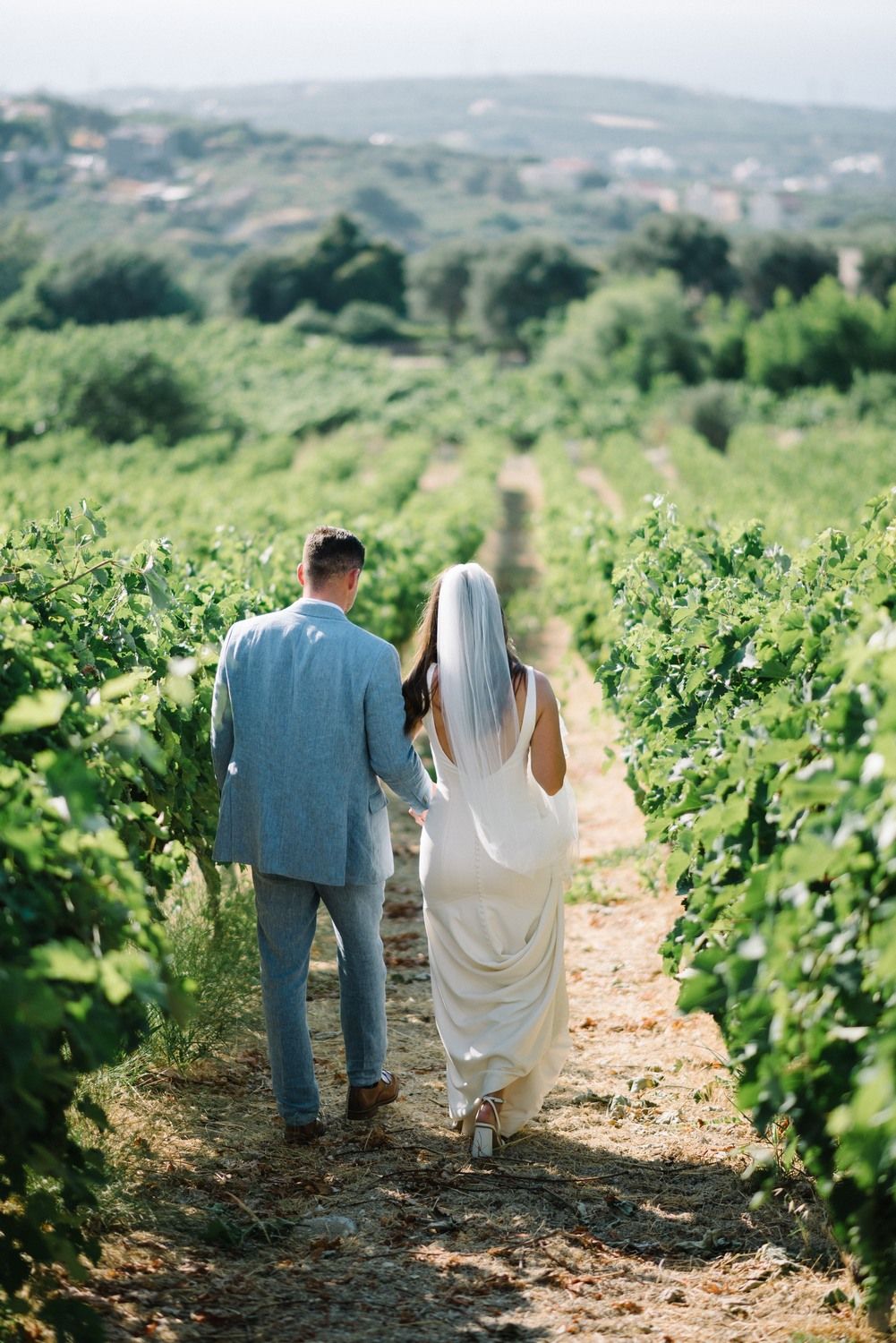 couple walking inside a vineyard at agreco farms in crete greece
