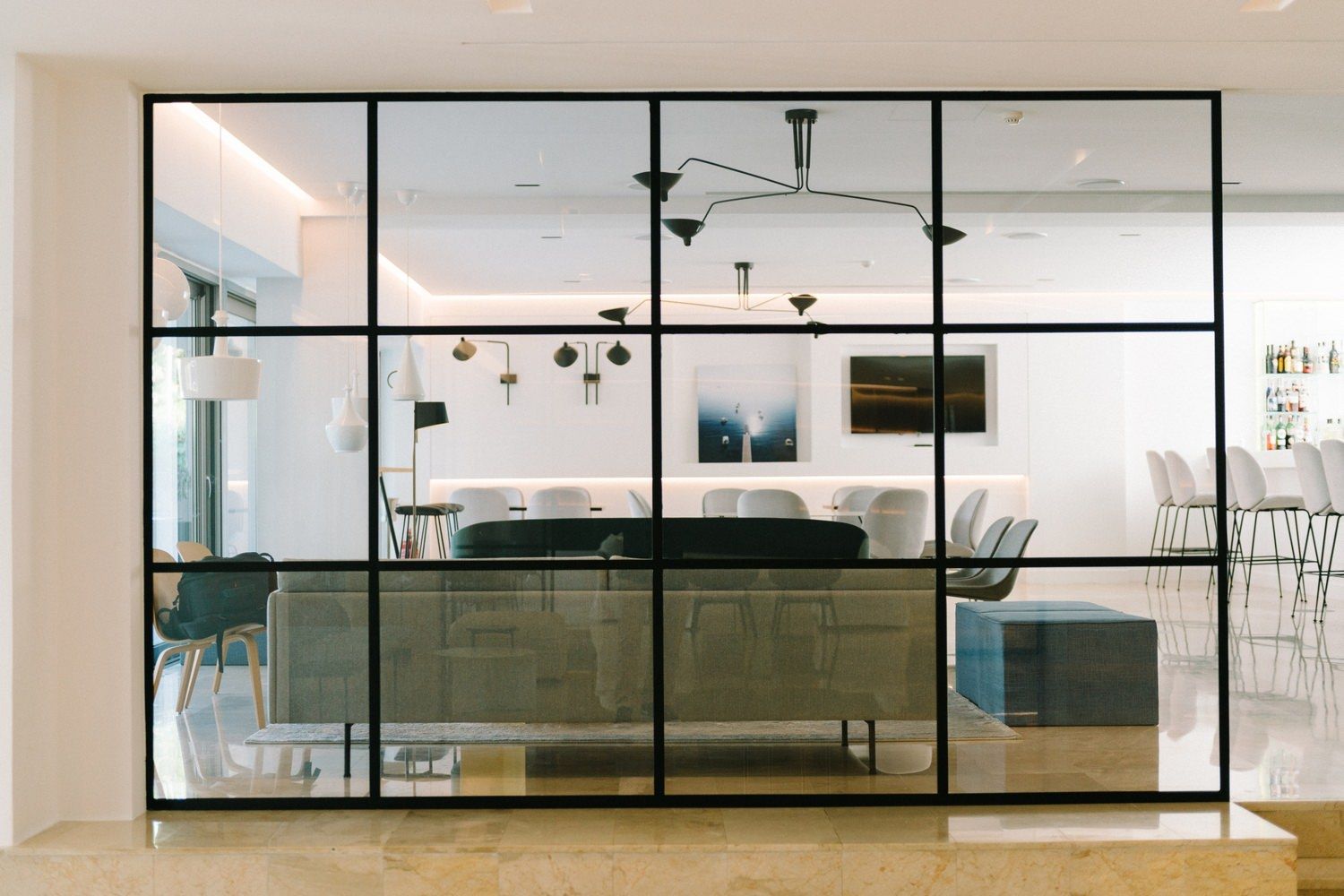 Modern office space with glass partition wall and contemporary furniture.
