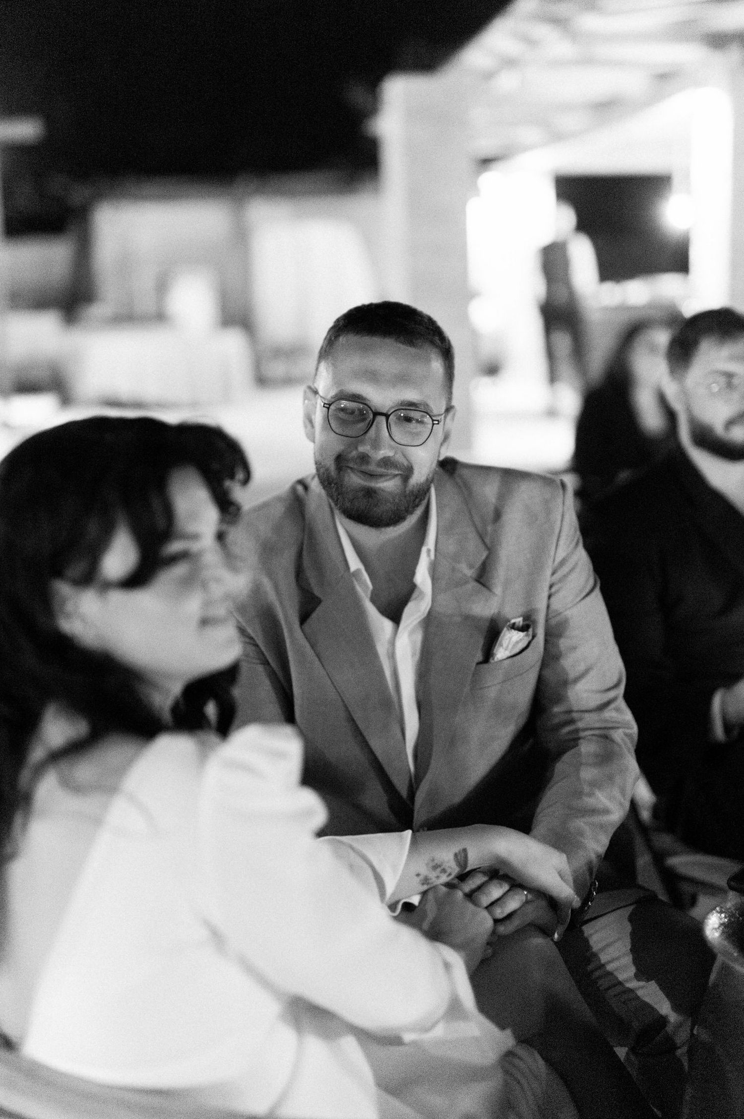 A black and white candid photo of guests at a formal event in conversation.