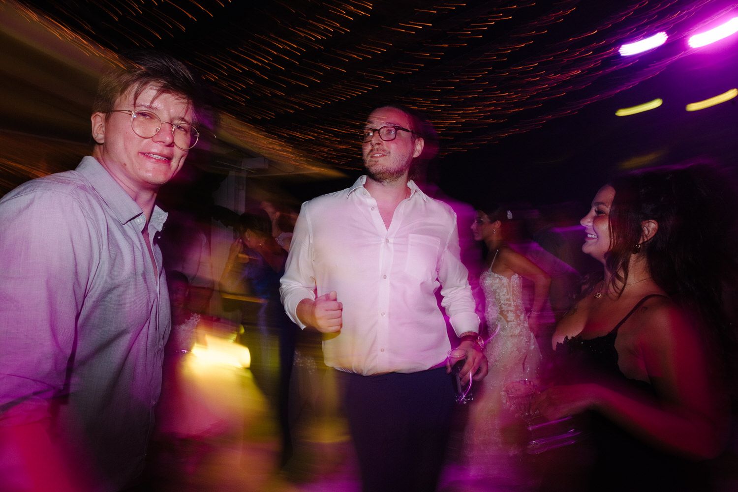 Party atmosphere captured with motion blur and vibrant purple lighting effects.