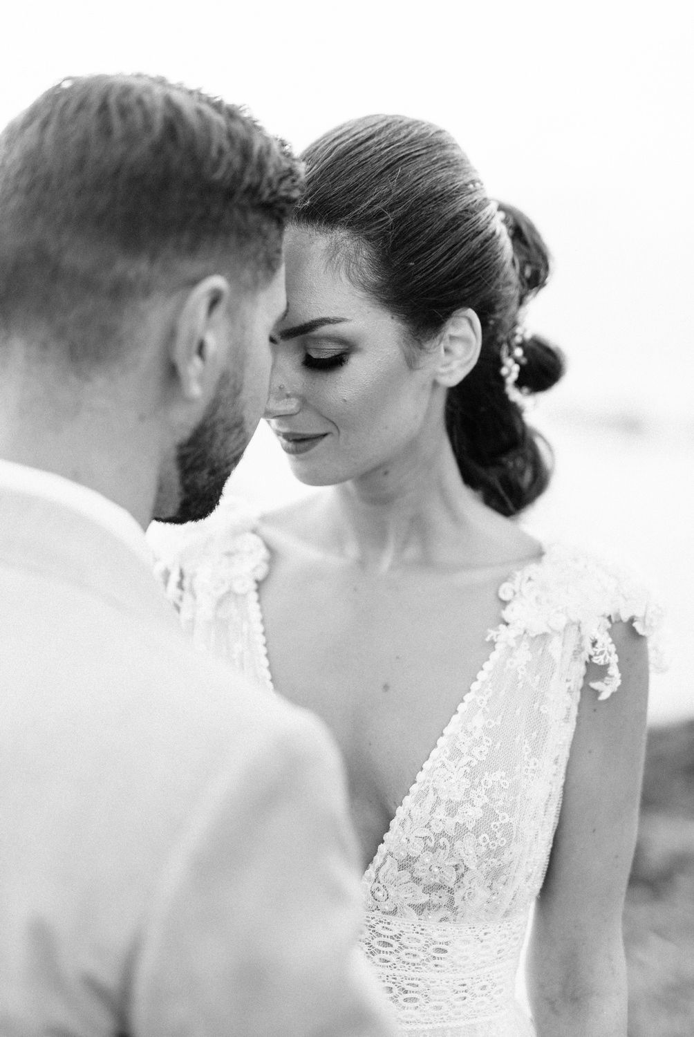Romantic black and white portrait of newlyweds sharing an intimate moment.