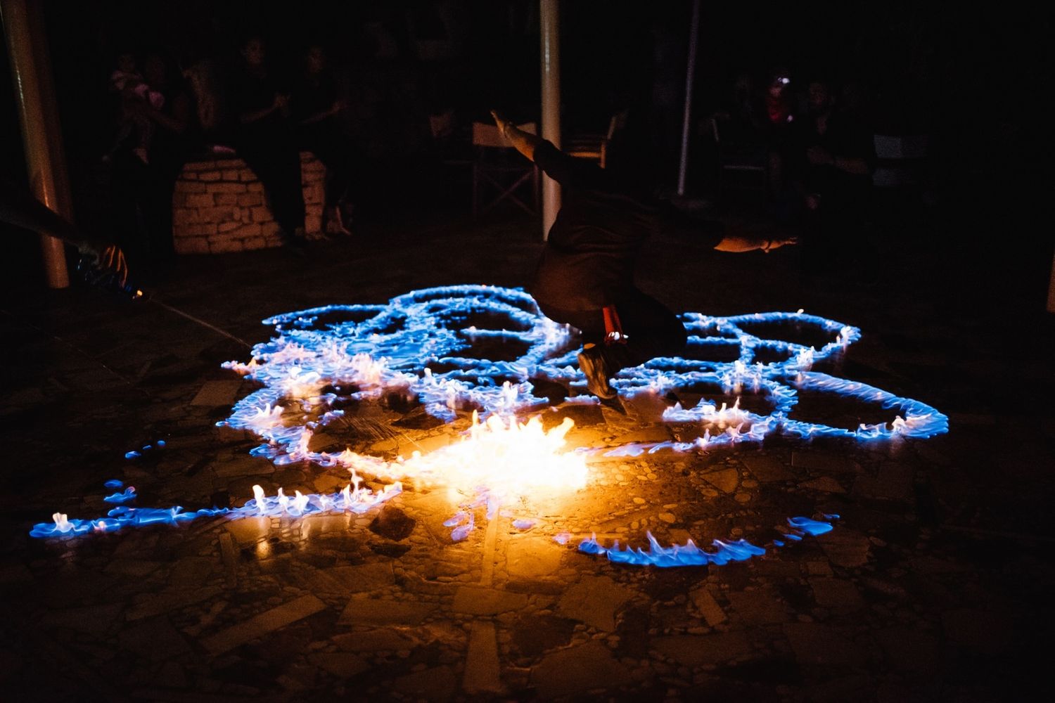 Light painting creates glowing blue patterns against dark night background.