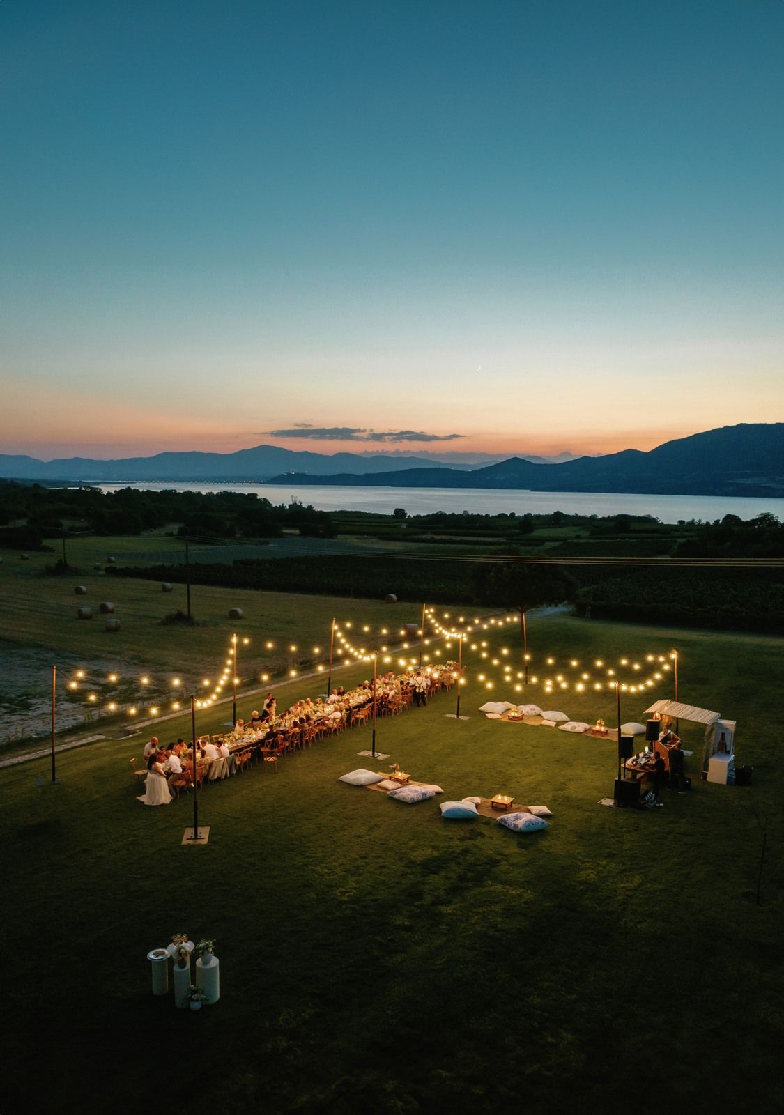 String lights illuminate an outdoor evening gathering setup at Kamkoutis vineyard at Velventos Kozani.