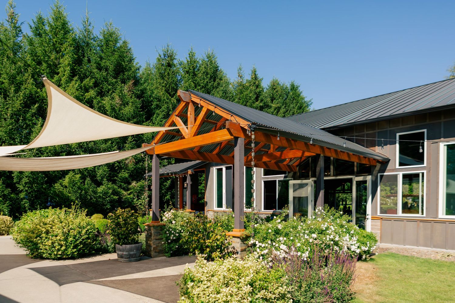 Modern wooden pergola structures create architectural interest and shade along the exterior of a contemporary home.