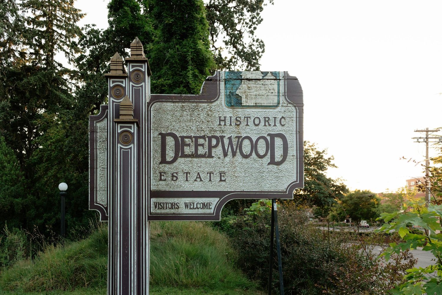 Historic Deepwood Estate welcome sign surrounded by lush green trees in Salem, Oregon.