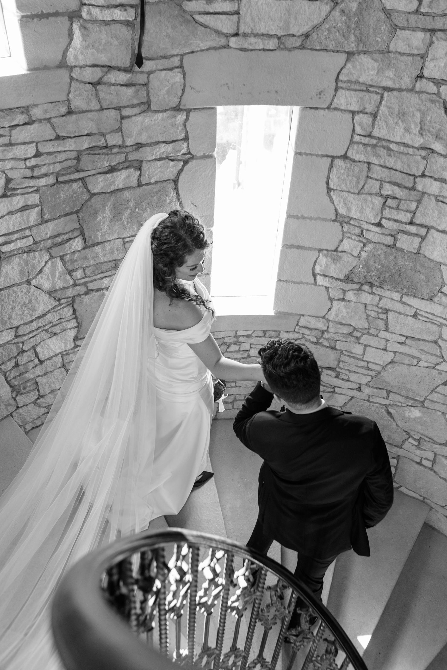 Behind-the-scenes black and white shots of a photographer capturing bridal portraits in a stone setting.