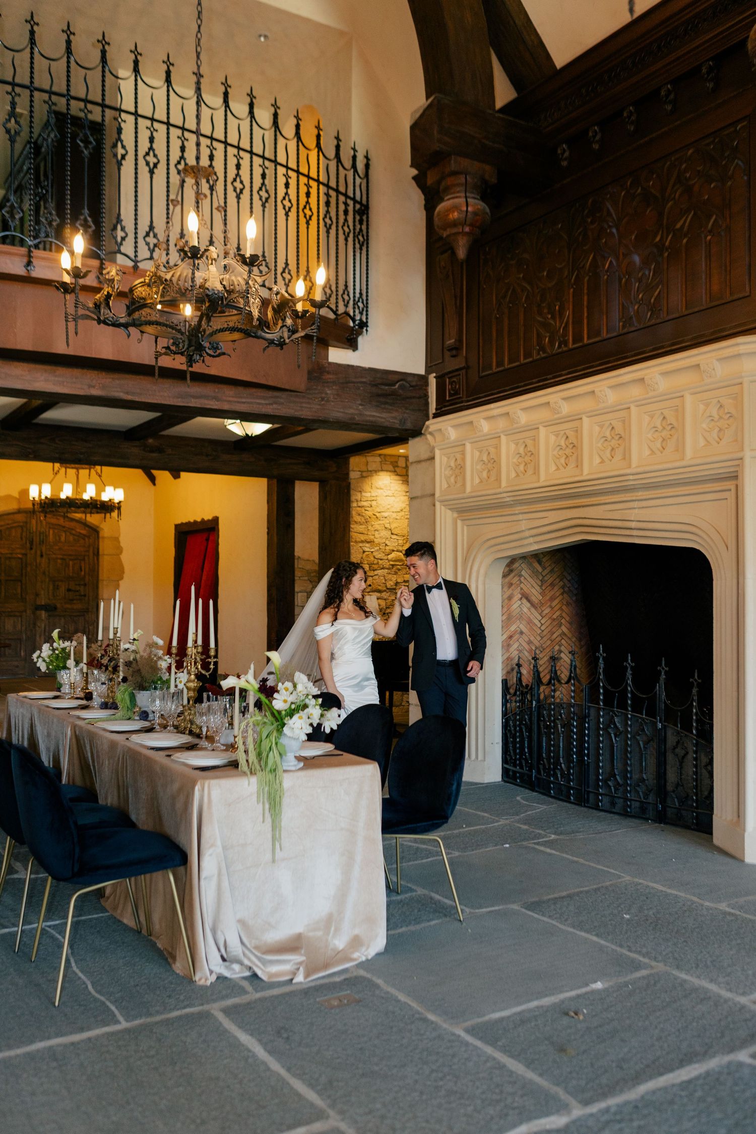 An elegant wedding reception venue with ornate iron railings, arched doorways and formal table settings.