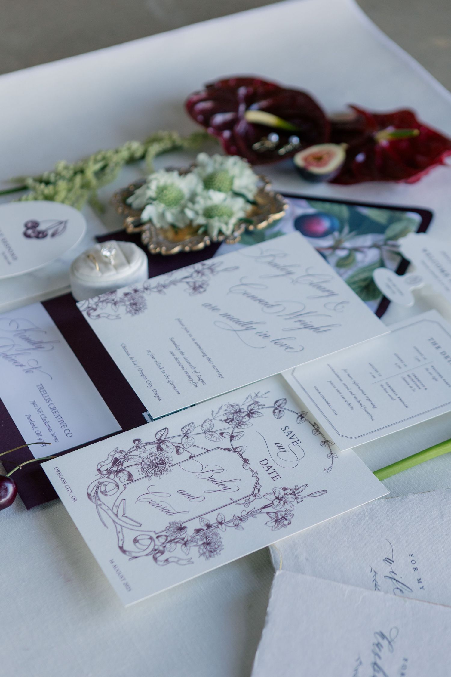 A series of white wedding invitation cards laid out on a table with floral designs and elegant script writing.