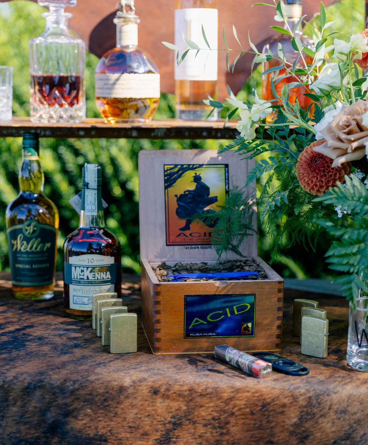 Wooden crates and potted plants create a rustic garden display with vintage decor elements on a textured wooden surface.