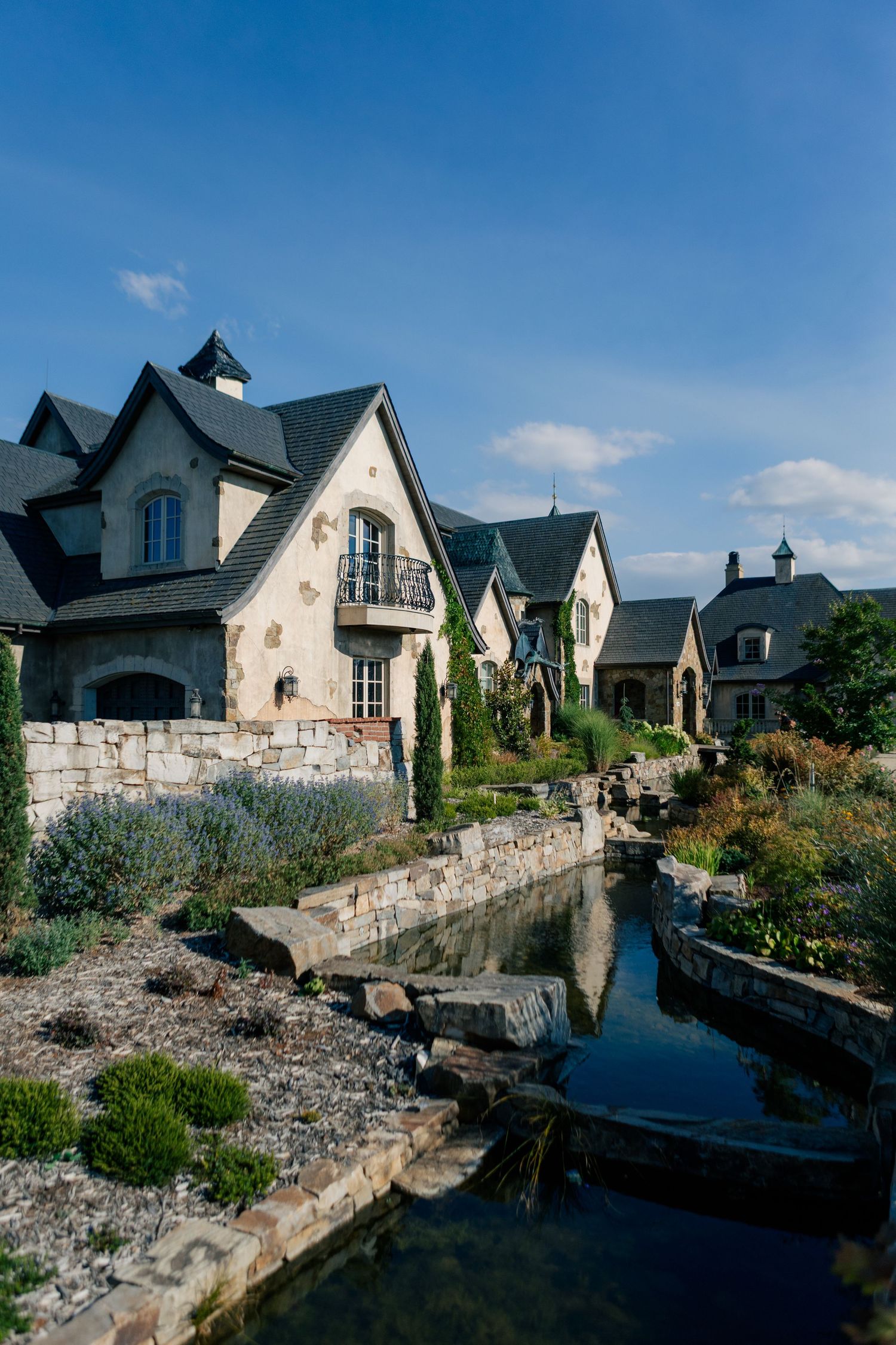 Carved stone terrace path with custom-designed modern houses set along a rocky waterfront in a coastal residential development.